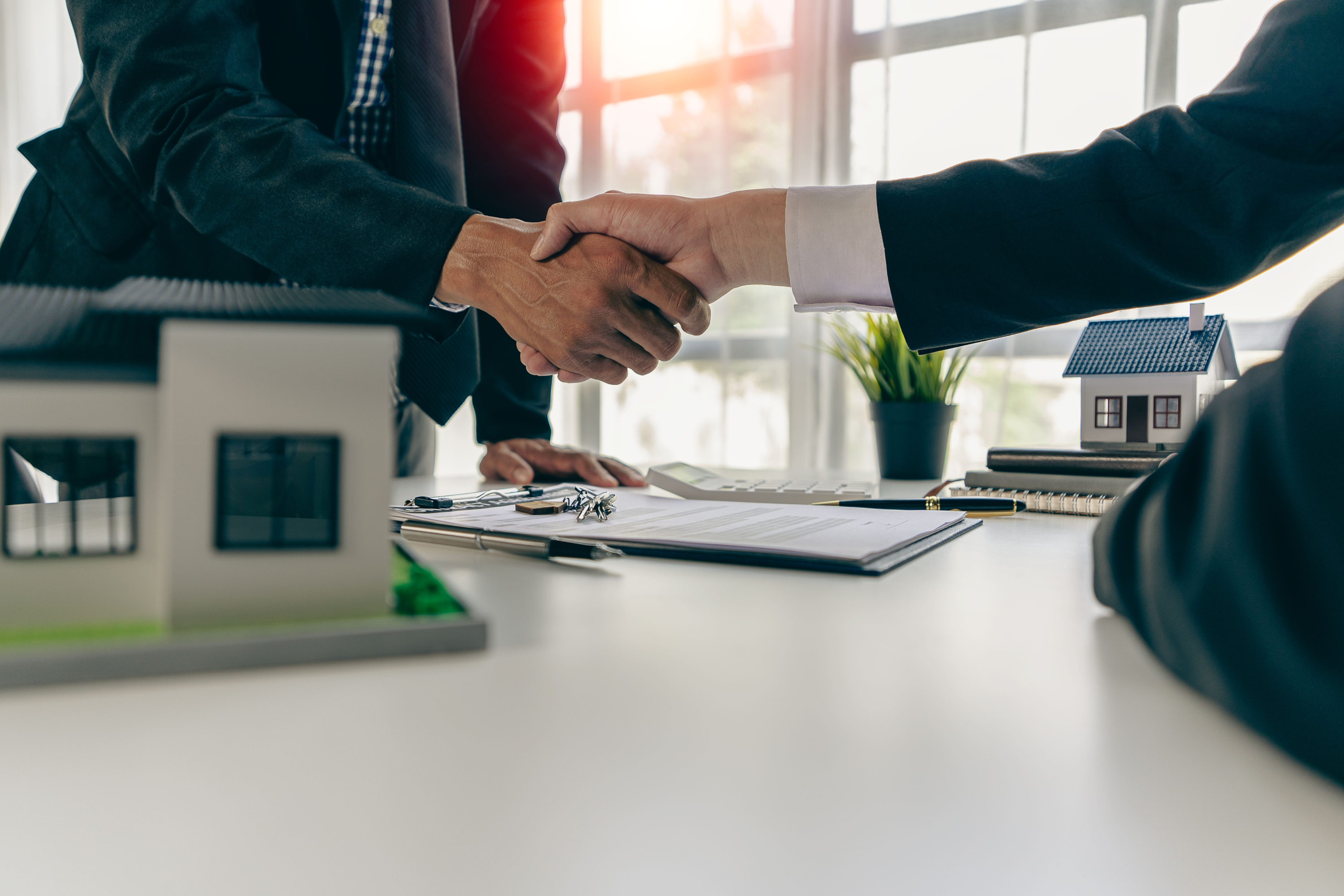 business people shaking hands over table